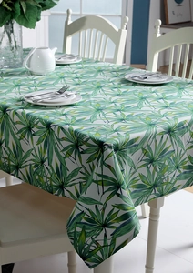 Close-up of thick cotton canvas tablecloth featuring vibrant green tropical palm leaf patterns