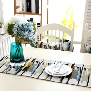 Detailed texture of cotton table runner featuring abstract blue and yellow stripes