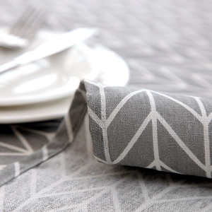Close-up of gray geometric tablecloth with white lines and cotton linen texture