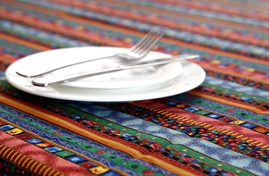 Detailed macro view of ethnic bohemian tablecloth with golden stripes and lace fringe