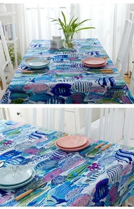Detail view of cotton tablecloth with colorful tropical fish patterns and hemmed edges