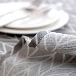 Close-up of grey geometric tablecloth showing cotton linen texture and fine edge stitching