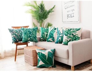 Close-up of tropical palm leaf and cactus print on natural linen cotton cushion cover