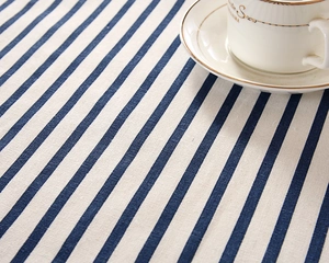 Macro detail of blue and beige striped cotton tablecloth with rustic woven texture