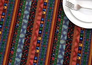 Macro detail of ethnic striped tablecloth with gold stamping and white ceramic dinnerware