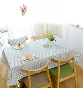 Detail of blue plaid waterproof tablecloth showing fabric texture on a modern wooden table