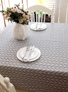 Close-up of modern grey herringbone geometric textured tablecloth in a cozy home setting