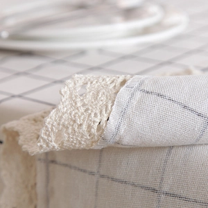 Detailed view of cream checkered cotton-linen tablecloth with delicate lace borders