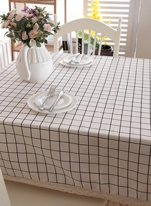 Detail of white and black grid tablecloth featuring elegant wide beige lace trim edges