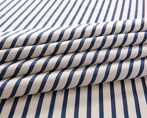 Close-up of navy and cream striped cotton fabric tablecloth with natural fold details