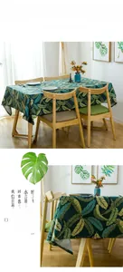 Detail of heavy cotton tablecloth with green tropical feather leaf patterns on dark base