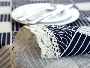 Close-up of geometric wave pattern tablecloth with delicate beige crochet lace edges