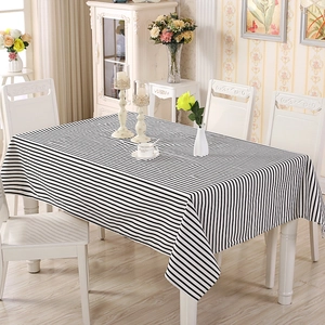 Detailed view of black and white striped tablecloth with elegant drape in home dining setting