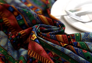 Macro shot of ethnic pattern tablecloth with golden stripes and elegant lace borders