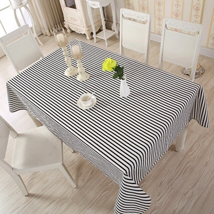 Detailed view of rectangular tablecloth with black and white stripes on a dining table
