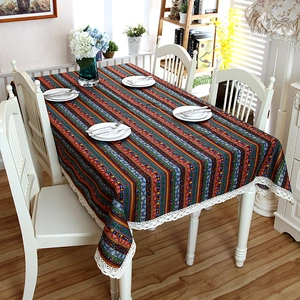 Detail of bohemian striped tablecloth featuring colorful patterns and white lace edges