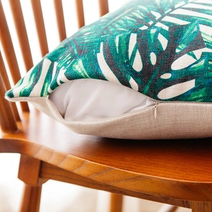 Linen cotton pillow cover with tropical leaf print and invisible zipper on chair