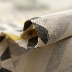 Close-up of geometric pattern tablecloth showing fine stitching and linen texture