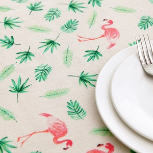 Detailed macro view of tropical flamingo and green leaf patterns on linen blend tablecloth