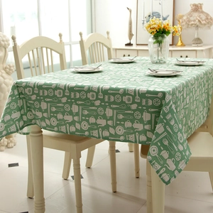 Close-up of sage green tablecloth with white kitchen tool patterns and linen texture