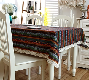 Detail of bohemian striped tablecloth with intricate white lace border on cotton linen fabric