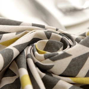 Macro detail of geometric polyester-cotton fabric with grey and yellow triangle patterns