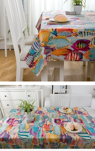 Detail of cotton tablecloth with tropical fish print on light blue fabric background