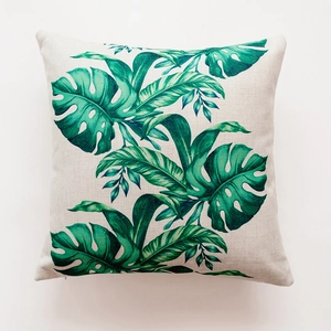 Detail of tropical monstera leaf print on heavy linen textured square cushion cover