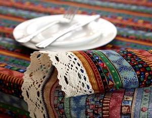 Close-up of ethnic style cotton linen tablecloth with intricate white lace border detail