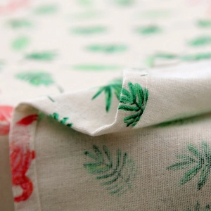Detailed macro view of linen-cotton fabric showing tropical flamingo and leaf prints
