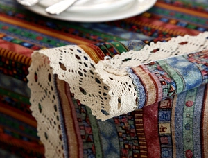 Detail of bohemian cotton linen tablecloth with ethnic stripes and lace trim