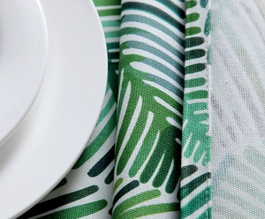 Close-up of thick cotton canvas tablecloth with tropical leaf print and neat stitched edges