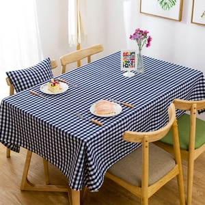Detail of blue and white plaid waterproof tablecloth on a rustic wooden dining table