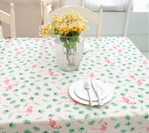Top view of rectangular tablecloth with flamingo and palm leaf patterns and fresh flowers