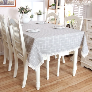 Close-up of grey and white plaid tablecloth with delicate lace trim on a dining table