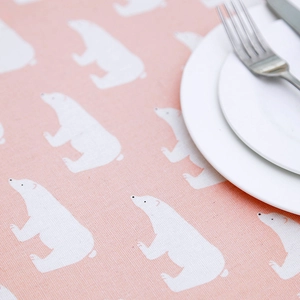 Detail showing pink tablecloth with white polar bear print and textured linen-like fabric