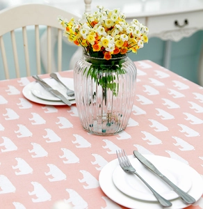 Detailed top view of pink table cloth with polar bear prints and a vase with flowers