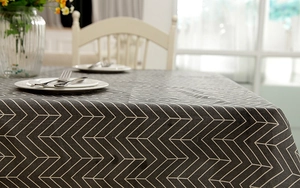 Detail of dark grey herringbone tablecloth with modern geometric pattern on dining table