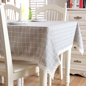 Close-up of gray and white plaid tablecloth with elegant cream lace edge trim detail