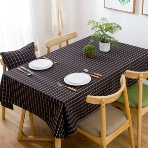 Close-up detail of dark charcoal plaid tablecloth with fine white grid pattern and fabric texture