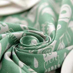 Close-up of green and white linen-cotton tea towel with abstract letter patterns