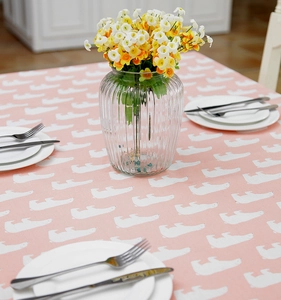 Pink table cloth featuring white polar bear patterns with dining plate and flower vase