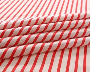 Detail shot of soft red and white striped cotton tablecloth fabric with woven texture