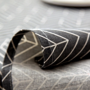 Detail of grey geometric herringbone tablecloth with neat stitching and cotton-linen texture
