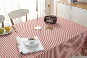 Close-up of red and white striped tablecloth with elegant white fringe tassel detailing