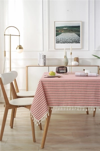 Detailed close-up of red and white striped tablecloth featuring elegant white tassel fringes