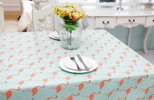 Detail of mint green flamingo print tablecloth with linen texture in a modern dining setting