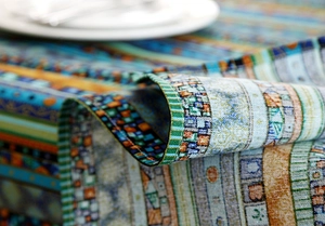 Close-up of bohemian gold-striped linen tablecloth featuring fine stitched edge detail
