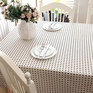 Modern beige tablecloth with black cross pattern in minimalist Nordic home setting