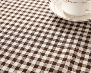 Macro detail of brown gingham tablecloth fabric texture with fine bone china cup